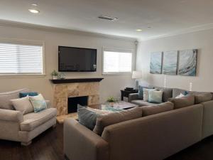 a living room with a couch and a fireplace at Gorgeous Pool Home 1/2 Mile Walk to Disney in Anaheim