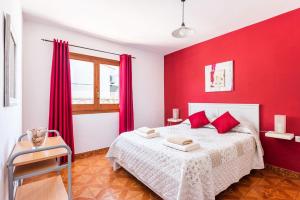 a bedroom with red walls and a bed with red pillows at Villa Dulcesol by Villa Select in Alaior +6 photos