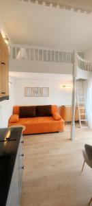 a living room with an orange couch and a loft bed at Dom Wypoczynkowy Oskar 250m od morza z sauną i jacuzzi in Jastrzębia Góra