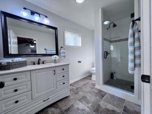 a bathroom with a sink and a shower with a mirror at Anaheim California, Beautiful Pool Home, Short Walk to Disney in Anaheim +22 photos