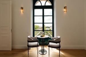 a table and chairs in a room with a window at Oca Grande Hotel Do Pezo in Melgaço