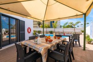 a table with chairs and a yellow umbrella on a patio at Villa Miramar Gale by Villa Select in Galé