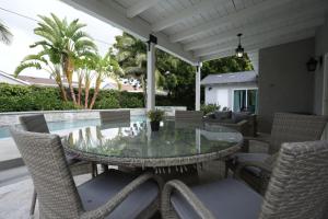 a patio with a glass table and chairs and a pool at 4 bedroom, 3 bathrooms Pool Home in Orange