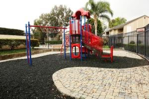 a playground with a red slide in a park at Luxurious 2 Bedroom Condo Shortest Walk To Disney in Anaheim