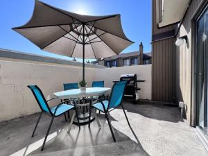 a table and chairs with an umbrella on a patio at Luxurious 2 Bedroom Condo Shortest Walk To Disney in Anaheim