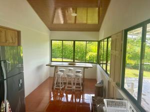 a kitchen with a bar with stools and windows at Casa Isabella in Ángeles