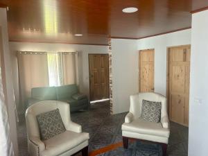 a living room with two chairs and a couch at Casa Isabella in Ángeles +8 photos