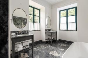 a bathroom with two mirrors and a sink at Oca Grande Hotel Do Pezo in Melgaço +52 photos