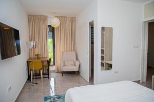 a bedroom with a bed and a desk and a chair at Casa Bianca in Accra