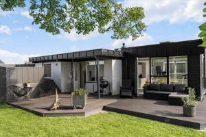 a black house with a patio and a yard at SJ236-Haderslev-Blokhusskoven-53 in Haderslev