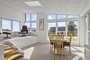 a living room with a table and chairs and windows at SJ236-Haderslev-Blokhusskoven-53 in Haderslev