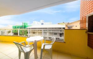 a balcony with a table and two chairs and a window at Residencial Dona Naime in Bombinhas