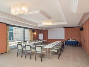 a conference room with tables and chairs and a screen at B&B HOTEL Napoli San Mauro in Casalnuovo di Napoli