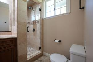 a bathroom with a shower and a toilet and a window at Charming Anaheim Home 1/2 Mile Walk to Disney in Anaheim +15 photos