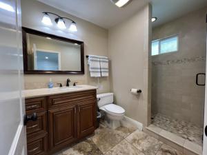 a bathroom with a toilet and a sink and a shower at Gorgeous Pool Home 1/2 Mile Walk to Disney in Anaheim +20 photos