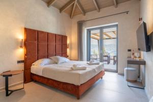 a bedroom with a large bed and a balcony at Villa Ouranos by Villa Select in Fiskardo +43 photos