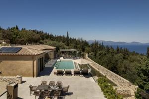 a house with a swimming pool and a villa at Villa Ouranos by Villa Select in Fiskardo