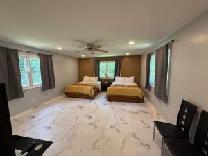 a bedroom with two beds and a ceiling fan at The Vineyard House | Spacious Home Near Wine, Beer & Lake MI in Bridgman