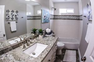 a bathroom with a sink and a tub and a toilet at Adorable 3 Bedroom 2 Bath Home in Fullerton