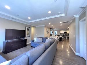 a large living room with a blue couch and a fireplace at Stunning 8 bedroom 6 bathroom Pool Home in Anaheim