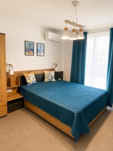 a bedroom with a bed with a blue comforter at Alta Vista Apollonia Sunset in Sozopol +21 photos