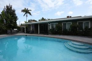 a large blue swimming pool in front of a house at Comfy Pool Home,1/4 mile Walk To Disneyland in Anaheim