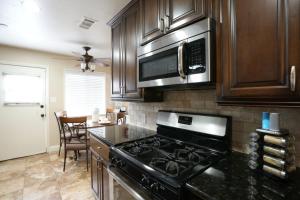a kitchen with a stove and a microwave at Comfy Pool Home,1/4 mile Walk To Disneyland in Anaheim