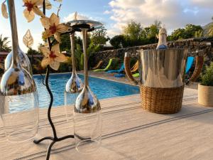 three wine bottles and a basket of flowers on a table at L'Escapade Volcanique in Sainte-Rose +10 photos
