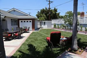 a yard with chairs and a table and a house at Stunning 8 bedroom 6 bathroom Pool Home in Anaheim