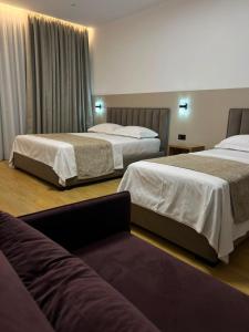 a hotel room with two beds and a couch at Skanderbeg Hotel in Krujë