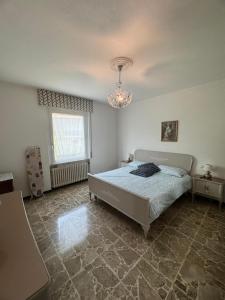 a bedroom with a bed and a chandelier at Casa Claudia in Riva di Solto