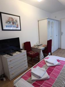a bedroom with a bed and a dresser with a tv at Rooms IVKA in Plitvička Jezera