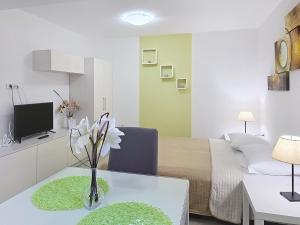 a room with a bed and a vase of flowers on a table at House Gorica 2 - underground level apartments in Baška