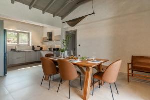 a kitchen and dining room with a wooden table and chairs at Villa Ouranos by Villa Select in Fiskardo