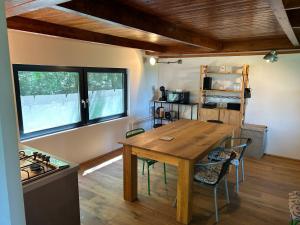 a kitchen with a wooden table and chairs in a room at KÉSA Faház in Balatonlelle