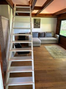 a white ladder in a living room with a couch at KÉSA Faház in Balatonlelle