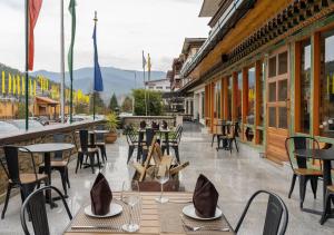 a restaurant with tables and chairs on a patio at The Willows Hotel, Bhutan in Thimphu