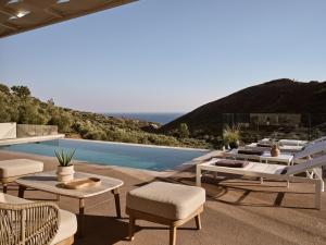 a patio with tables and chairs and a pool at Villa Zeta by Villa Select in Kalamaki