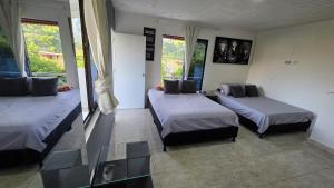 a room with two beds and a glass table at CASA HOTEL COCORNa in Cocorná