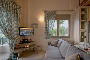 a living room with a couch and a window at Villa Sandy Evi by Villa Select in Astérion