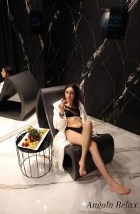 a woman sitting on a chair with a plate of food at Relax in Puglia in Corato
