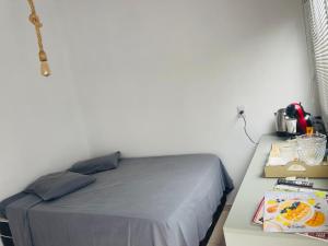 a bed in a room with a table with a bed sidx sidx at Pousada Coral in Osório
