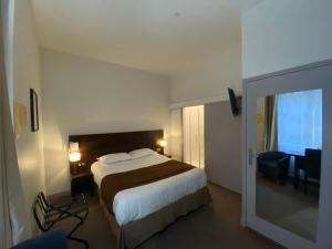 a hotel room with a bed and a sliding glass door at Hotel de Montaulbain in Verdun-sur-Meuse
