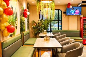 a restaurant with tables and chairs and a tv at Royal Awadh Inn Near Shree Ram mandir in Ayodhya