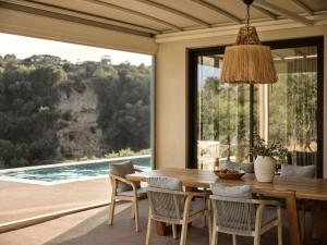 a dining room with a table and a large window at Villa Zeta by Villa Select in Kalamaki