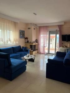 a large living room with blue couches and a table at LULA 'S HOUSE in Iraklitsa