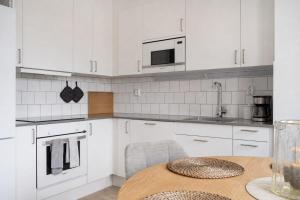 a kitchen with white cabinets and a wooden table at Luxurious apartment in central Grebbestad! in Grebbestad +10 photos