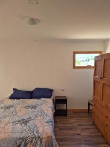 a bedroom with a bed and a dresser at Los Olivos del Colibri in Tambillos