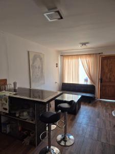 a living room with a table and two bar stools at Los Olivos del Colibri in Tambillos +1 photo