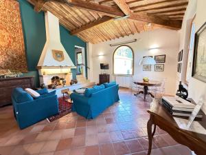 a living room with blue couches and a table at Villa Santa Chiara in Siena